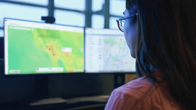 security analyst looking at two monitors in the London assistance center